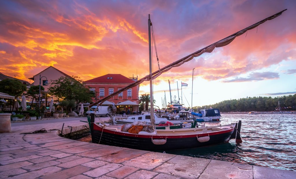 stari grad harbor at sunset with pink skies on the island of hvar, croatia
